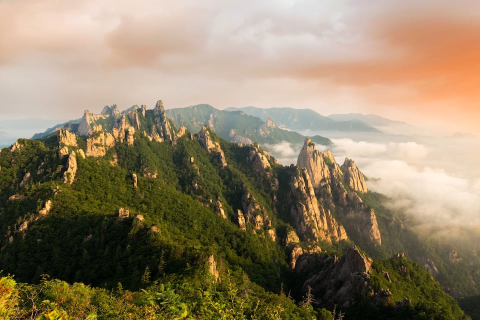 A mountainous landscape with rocky peaks and lush greenery.