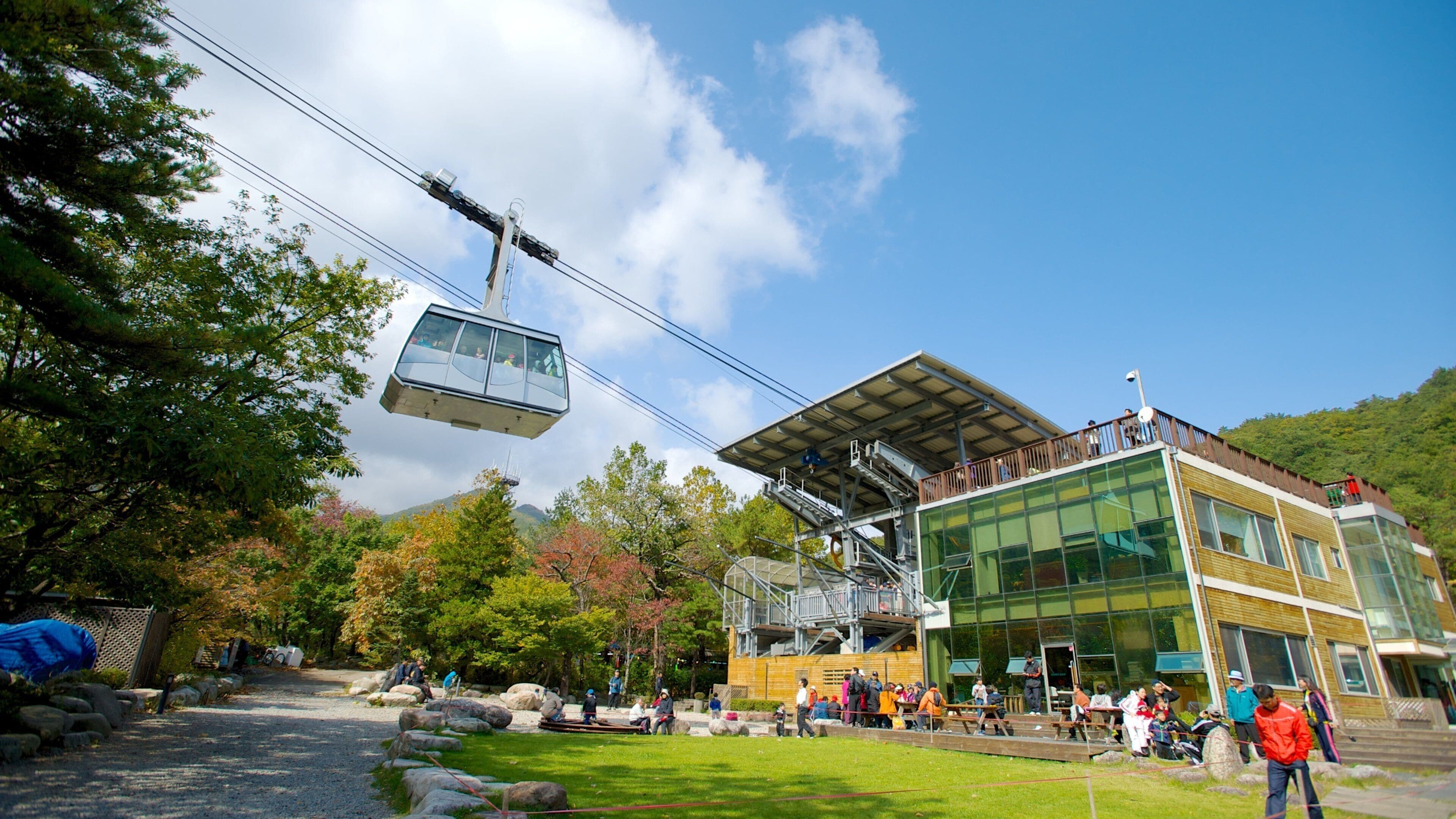 A cable car system, a modern building, and a mountainous landscape.