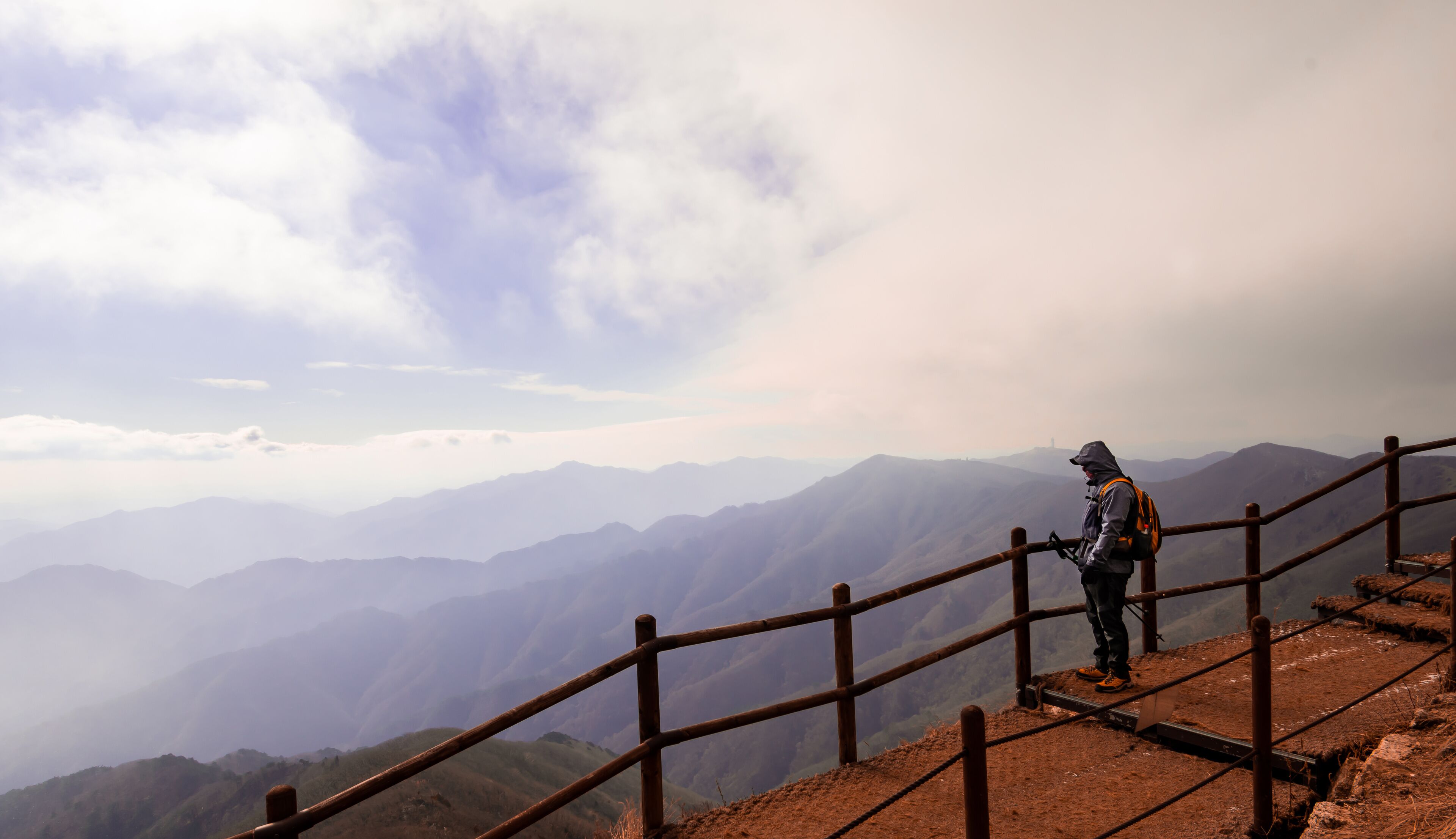 Hiker on the ridge of Sobaek Mountain in Danyang, South Korea looks out over the horizon. 