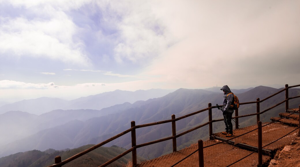 Hiker on the ridge of Sobaek Mountain in Danyang, South Korea looks out over the horizon.