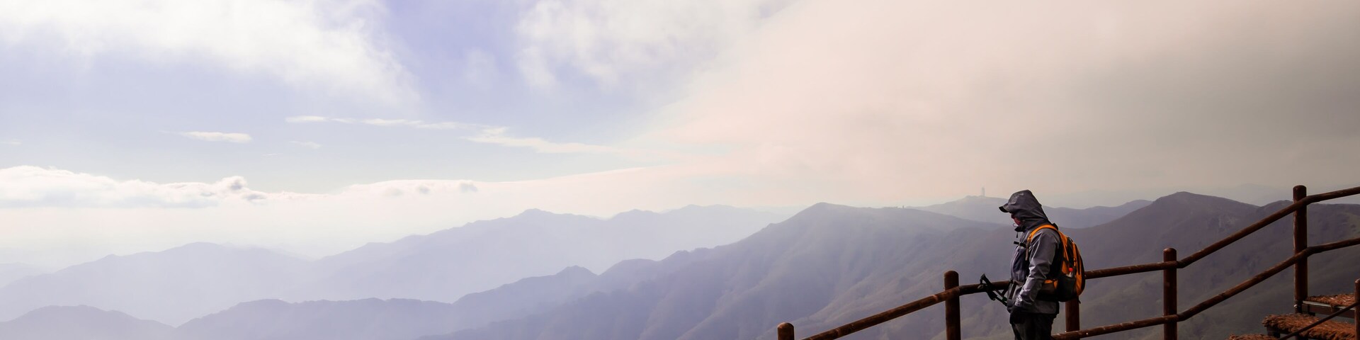 Hiker on the ridge of Sobaek Mountain in Danyang, South Korea looks out over the horizon.
