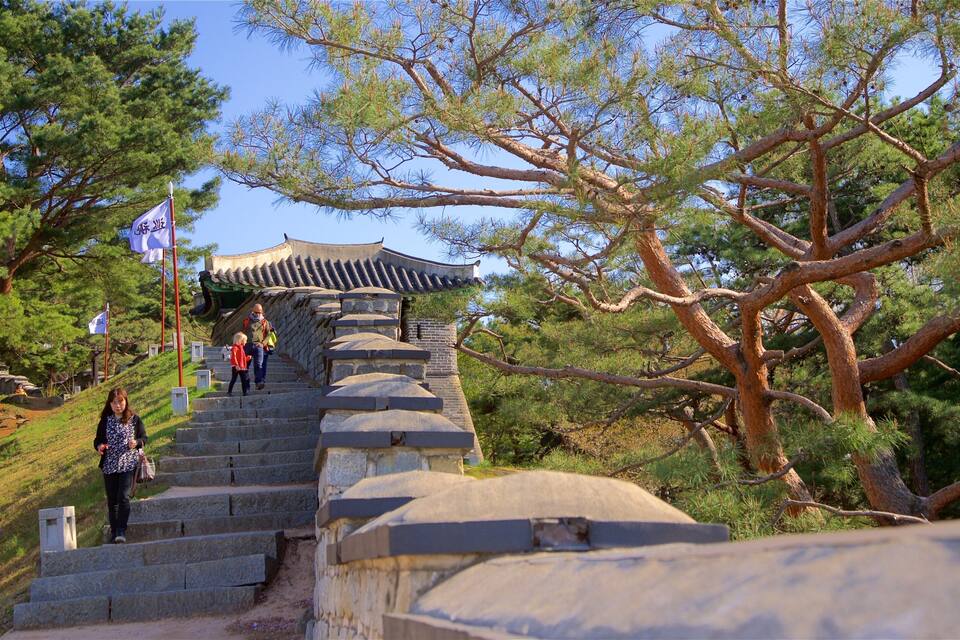 Un escalier en pierre mène à un bâtiment traditionnel coréen doté d’un toit recouvert de tuiles.