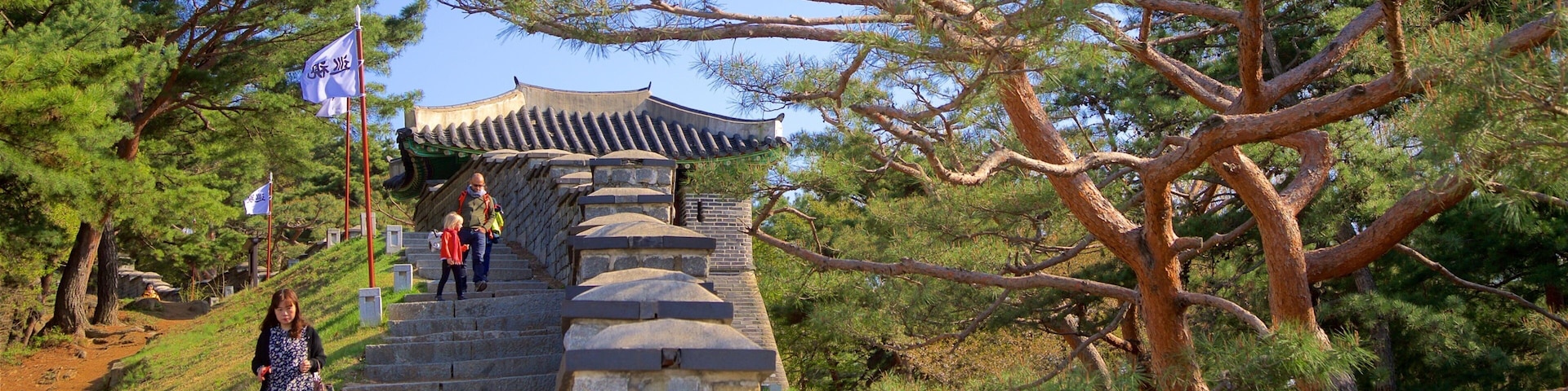 Hwaseong Fortress featuring heritage elements and a garden as well as a small group of people