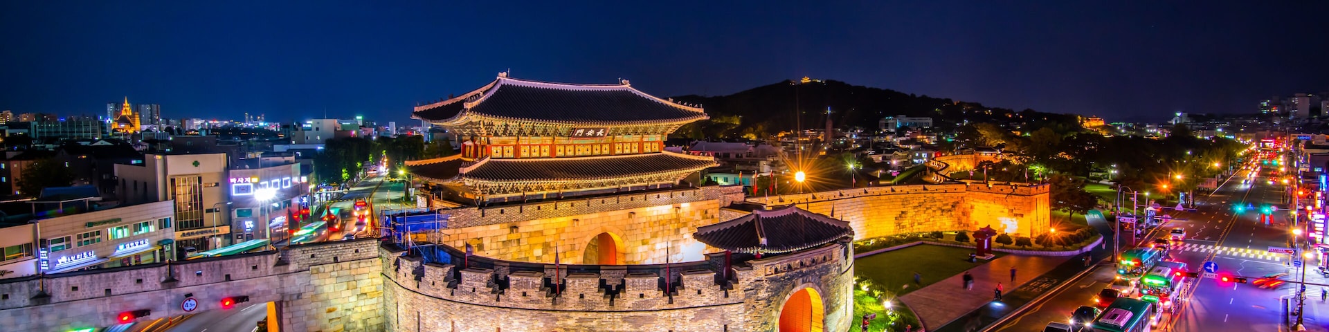 Una ciudad histórica amurallada con arquitectura tradicional iluminada durante la noche.