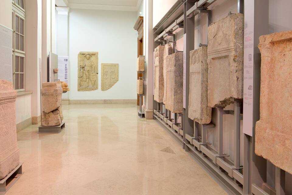 Um corredor de museu com artefatos antigos de pedra em exposição.