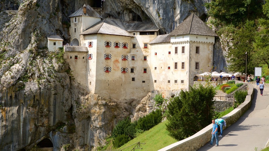 Predjama Castle featuring heritage architecture and a coastal town