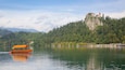 Castillo de Bled mostrando un lago o abrevadero, escenas forestales y paseos en lancha