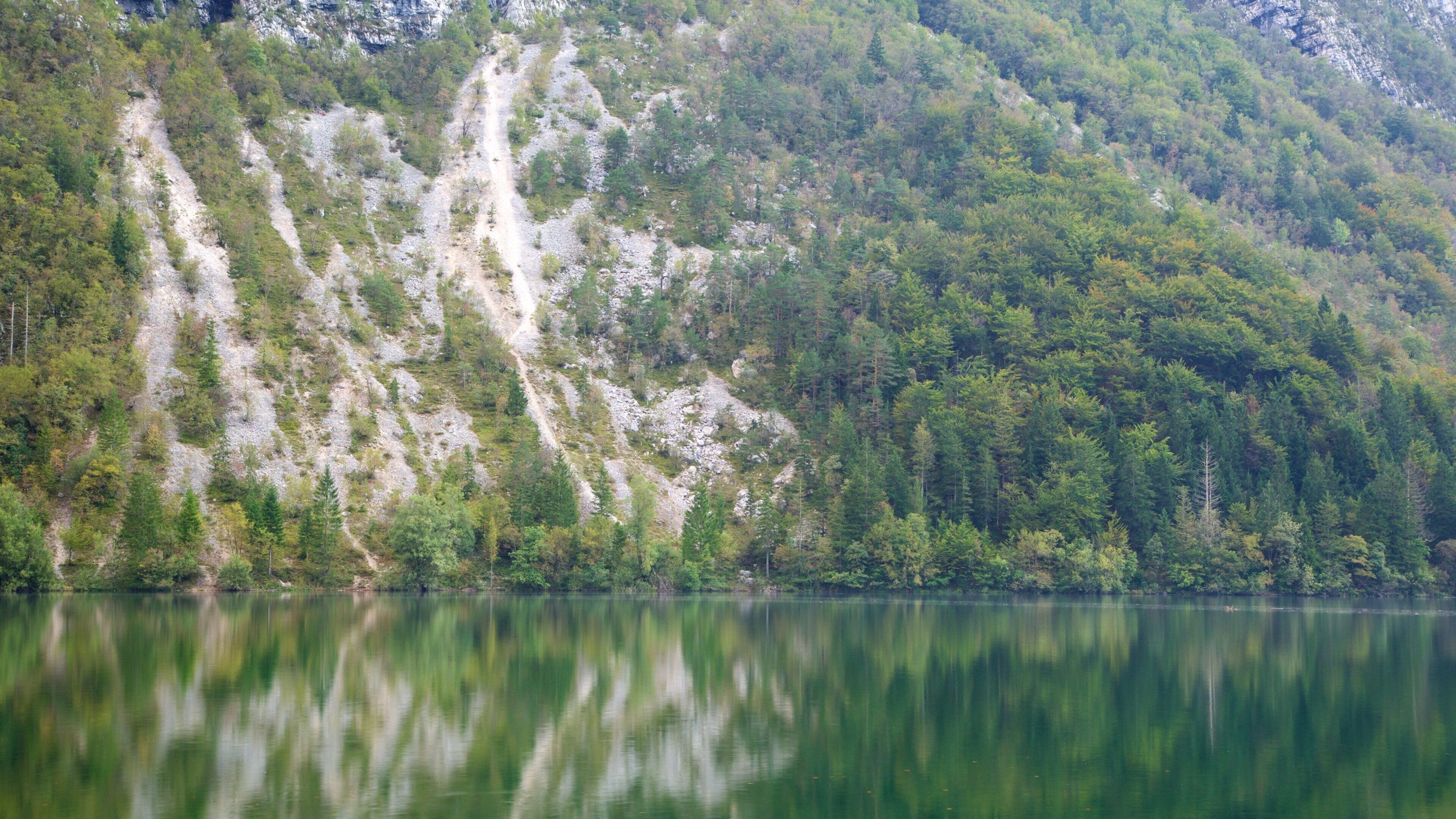 Lake Bohinj which includes mountains and a lake or waterhole