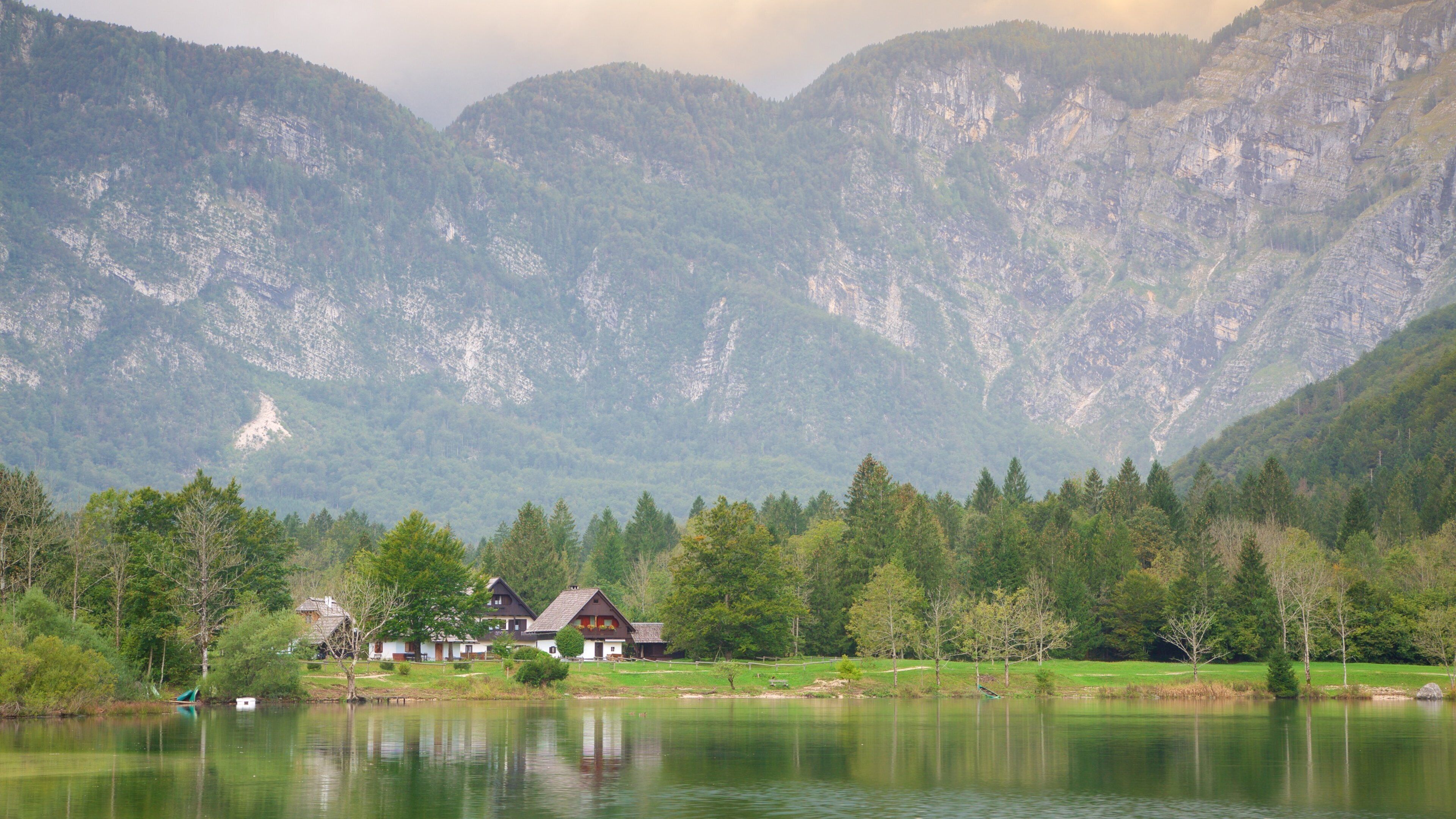 Lake Bohinj which includes mountains, a small town or village and a lake or waterhole