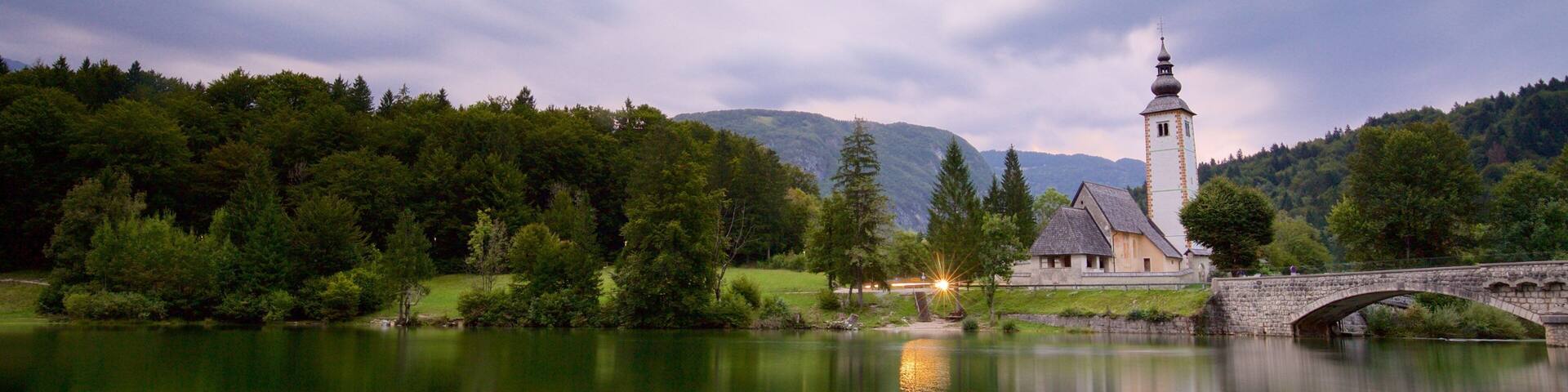 Lago Bohinj mostrando un puente, una iglesia o catedral y un lago o abrevadero
