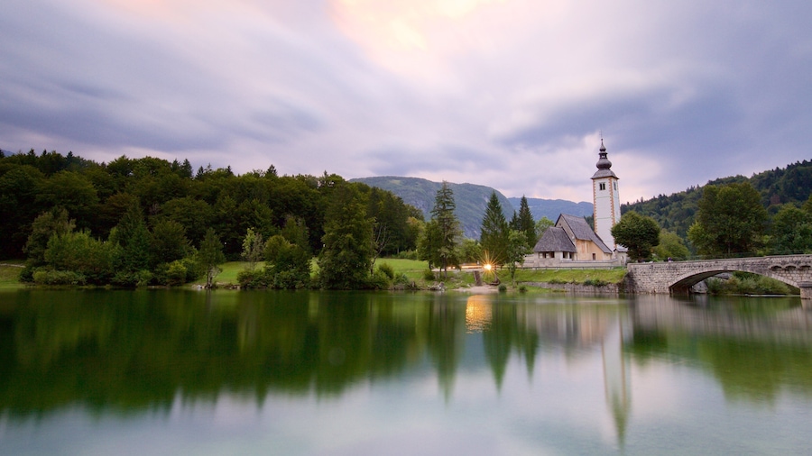 Lake Bohinj featuring a lake or waterhole, a bridge and a church or cathedral