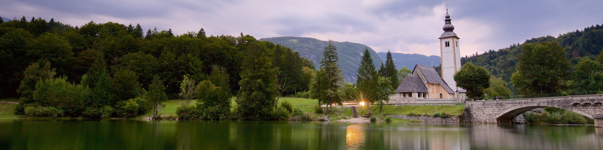 Lake Bohinj showing a church or cathedral, a lake or waterhole and a bridge