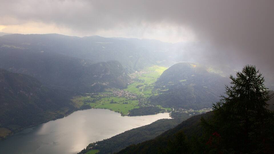 A valley with a lake surrounded by mountains and a small town.