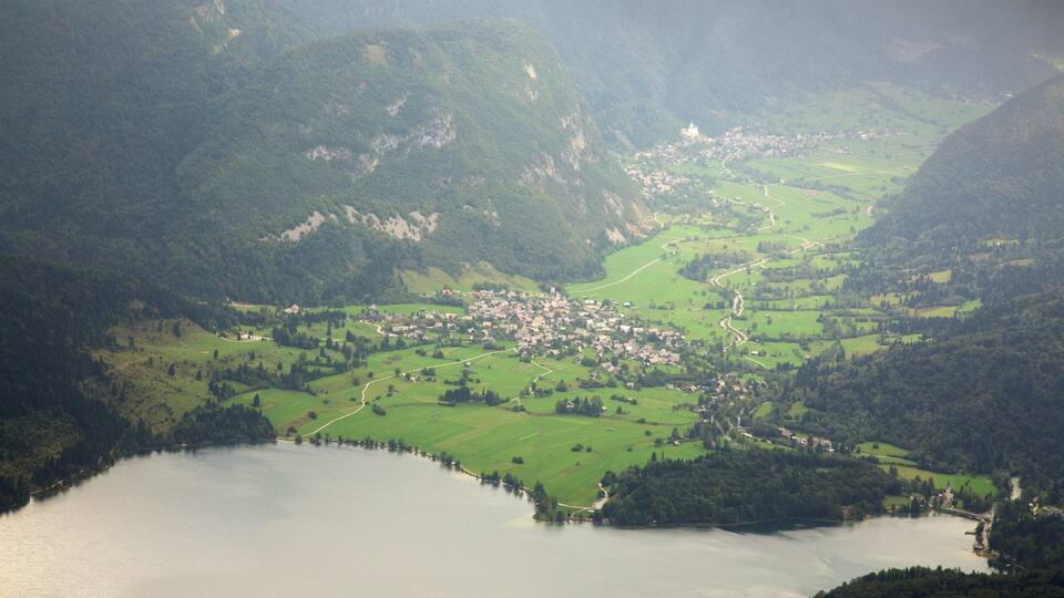 A mountainous landscape with a small village and a lake.