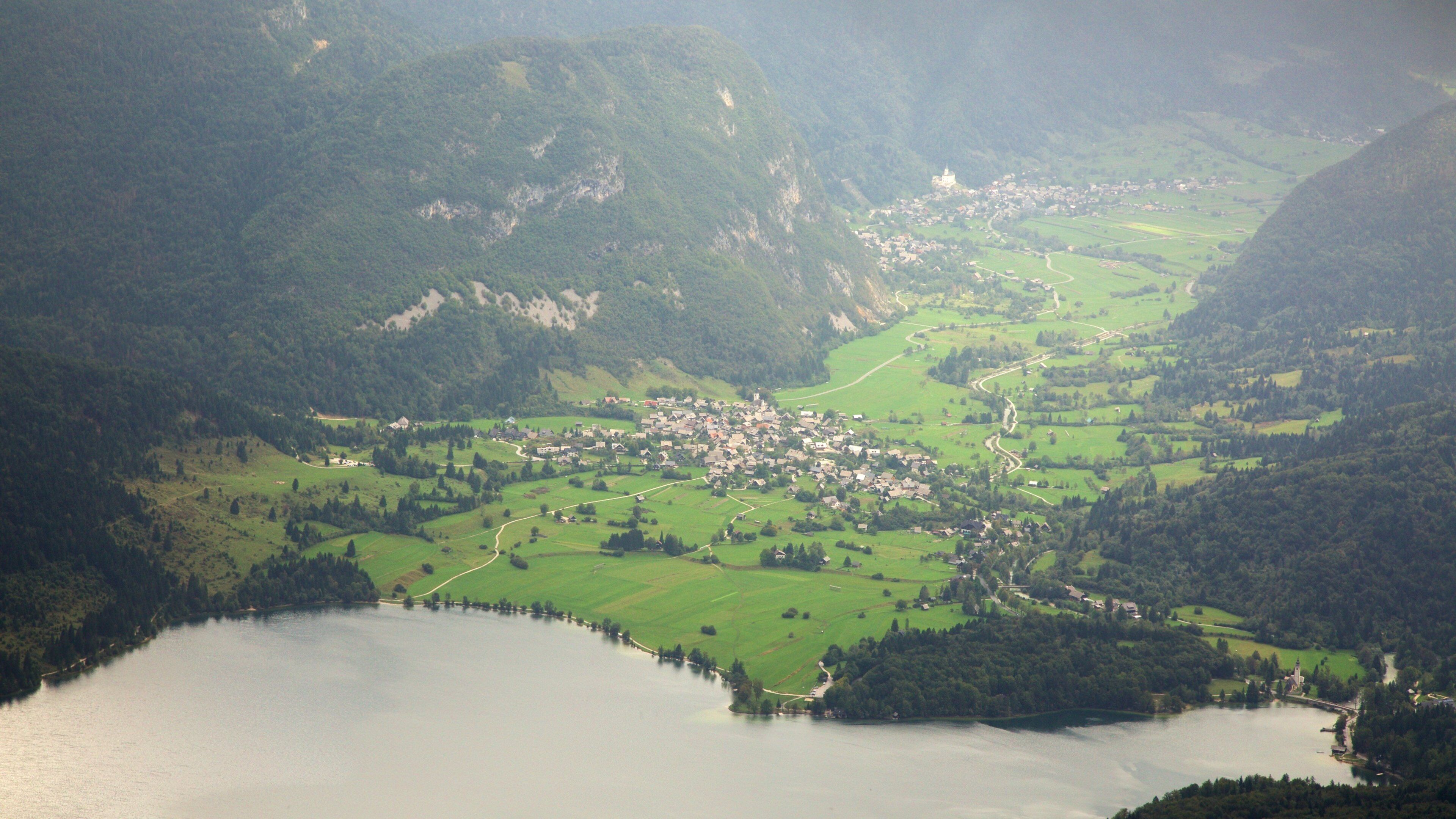 A mountainous landscape with a small village and a lake.
