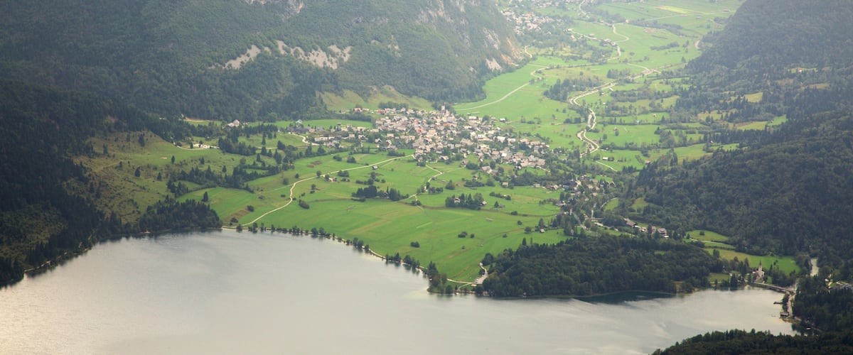 A mountainous landscape with a small village and a lake.