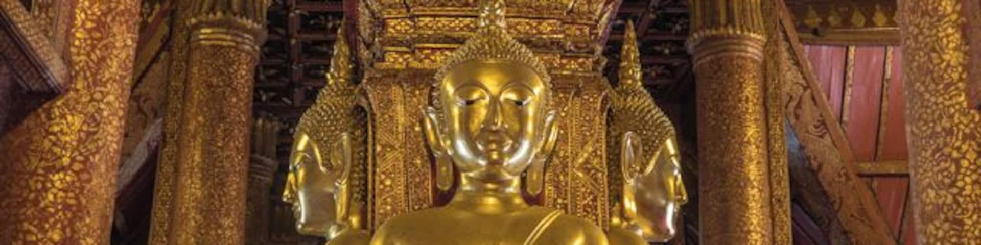 Wat Phumin was built in 1596. Its design is unusal for a Thai Wat as it has four daors facing in cardinal directions. Entering through any door will bring you to a seated Buddha with one hand touching the ground, Earth witness position.
More:
http://www.wornwheels.com/th_watphumin.php