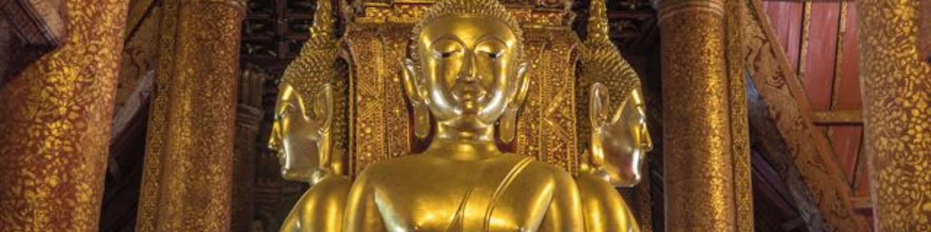 Wat Phumin was built in 1596. Its design is unusal for a Thai Wat as it has four daors facing in cardinal directions. Entering through any door will bring you to a seated Buddha with one hand touching the ground, Earth witness position.
More:
http://www.wornwheels.com/th_watphumin.php