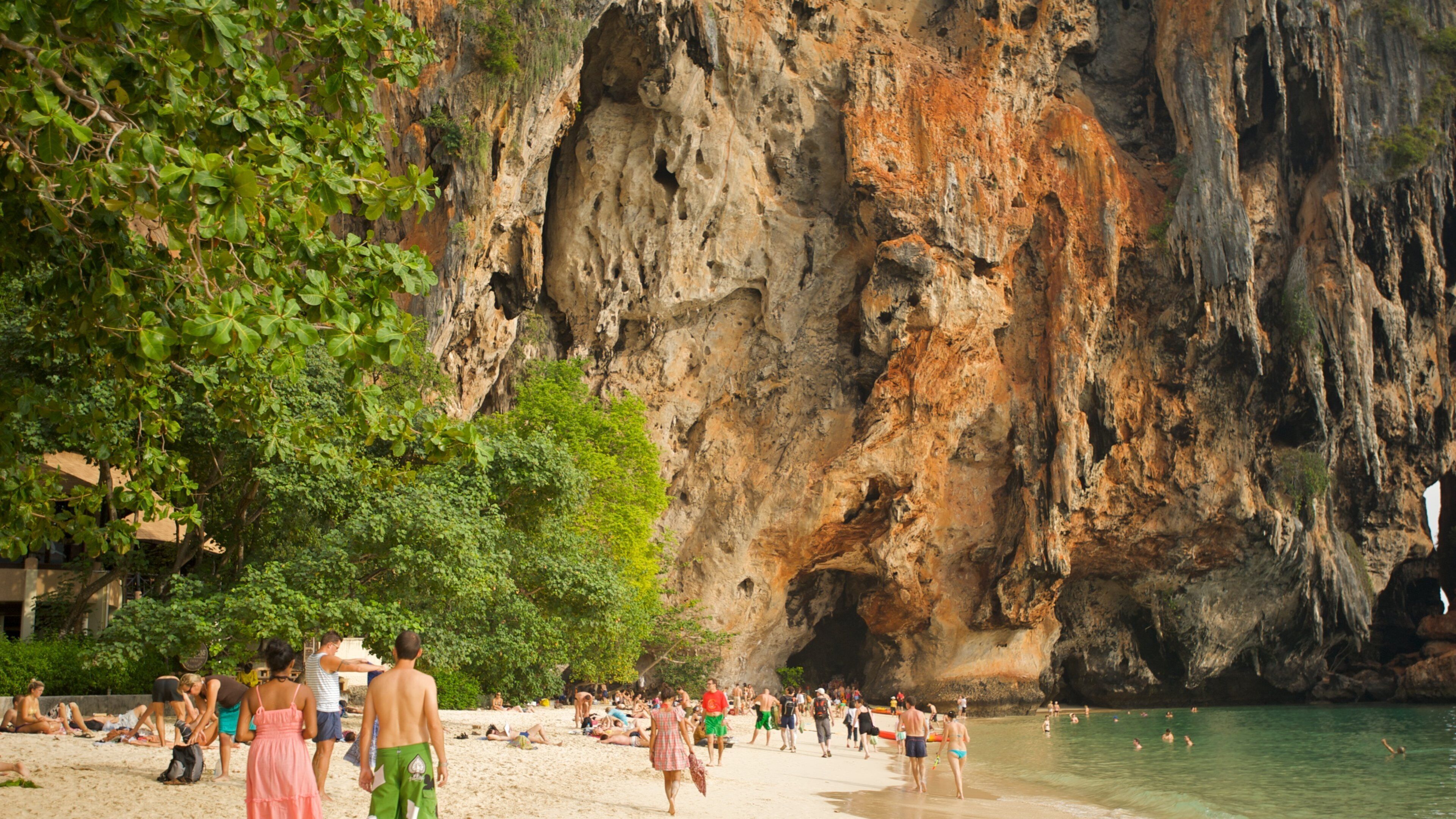 West Railay Beach featuring a sandy beach and a gorge or canyon as well as a large group of people