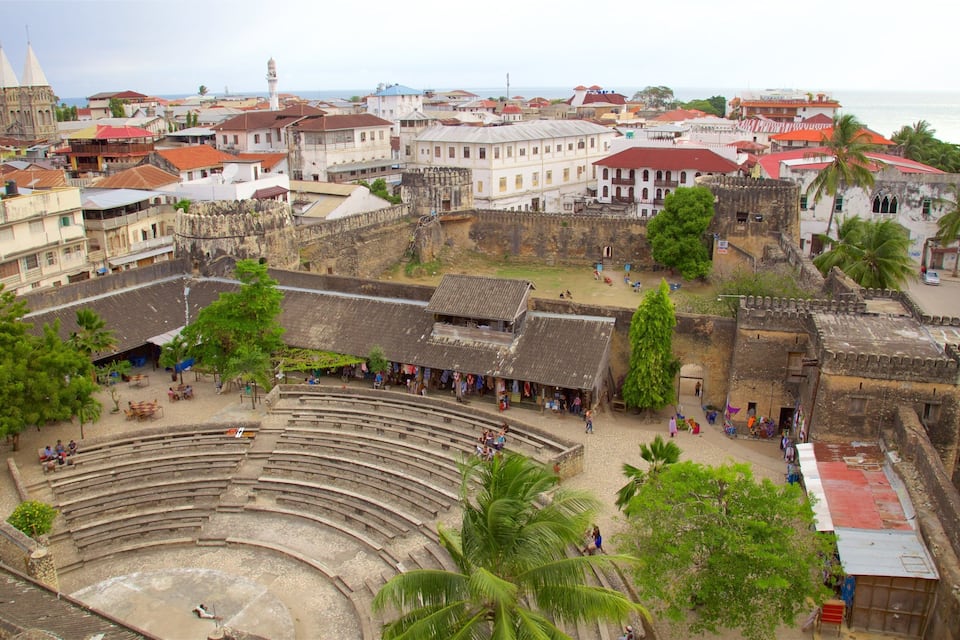 Un amphithéâtre entouré de bâtiments historiques et de palmiers.