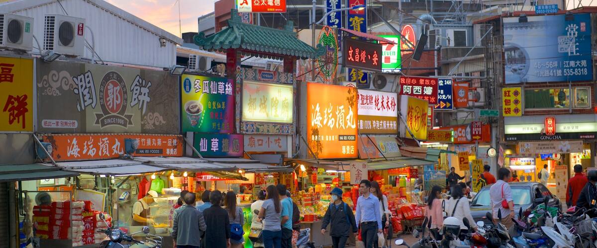 A bustling street market with various shops and signs in a foreign language.