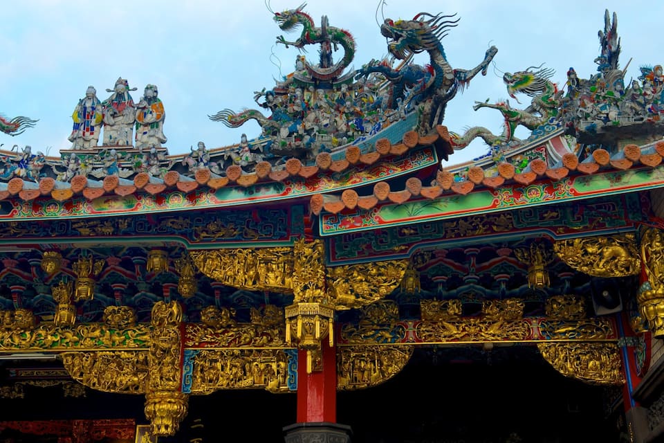 A traditional Chinese temple roof with ornate golden decorations and dragon sculptures.