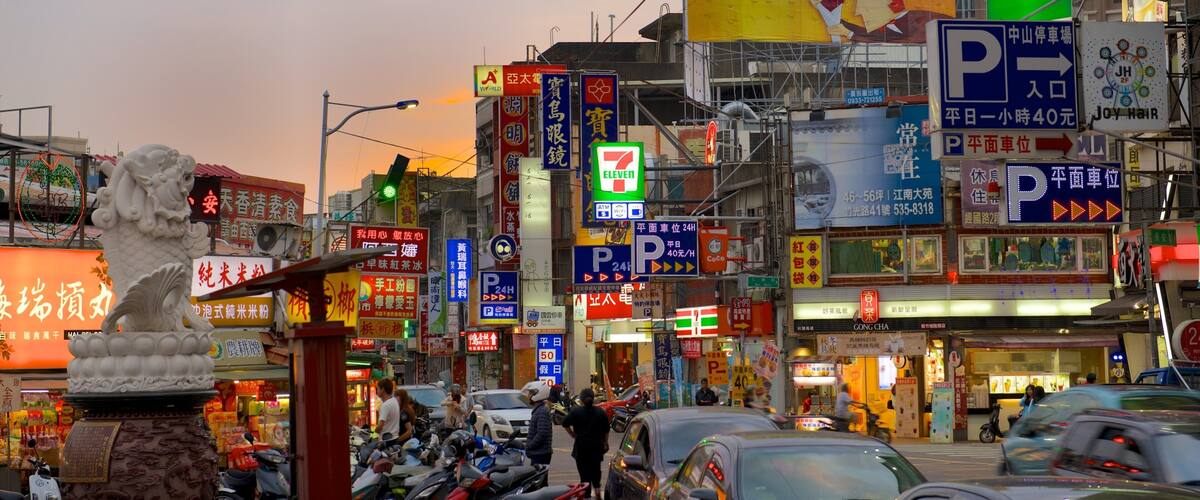 A busy urban street with various shops, a 7-Eleven, and a statue of a lion.