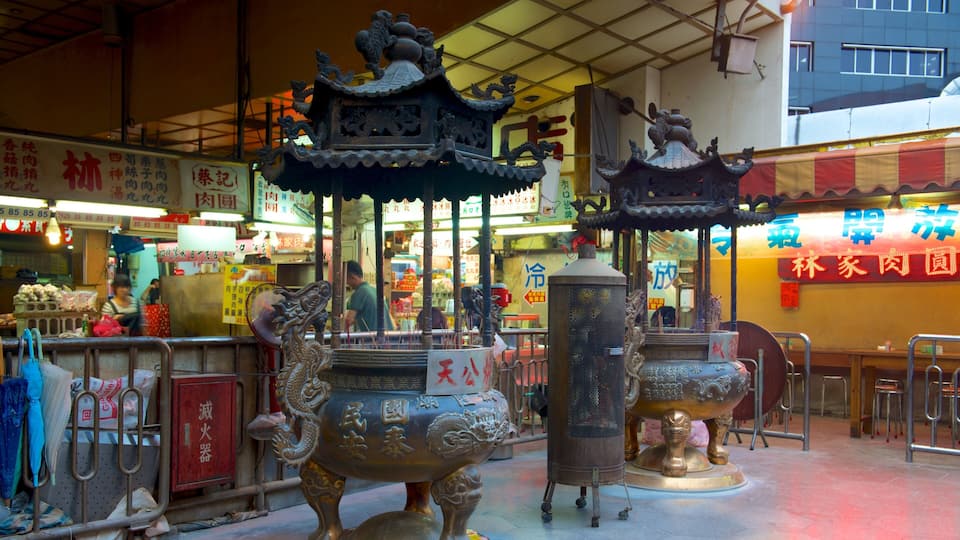 Un temple chinois traditionnel, orné de statues de dragons et doté de brûleurs d’encens.
