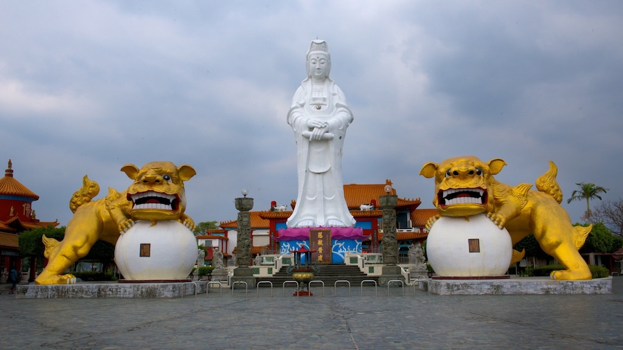 A statue of a woman in traditional attire flanked by two lion statues.