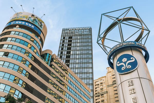 A modern building with a curved facade and a large sign with Chinese characters.