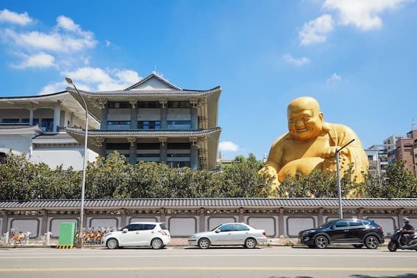 Ein traditionelles Gebäude mit einer großen, goldenen Statue davor.