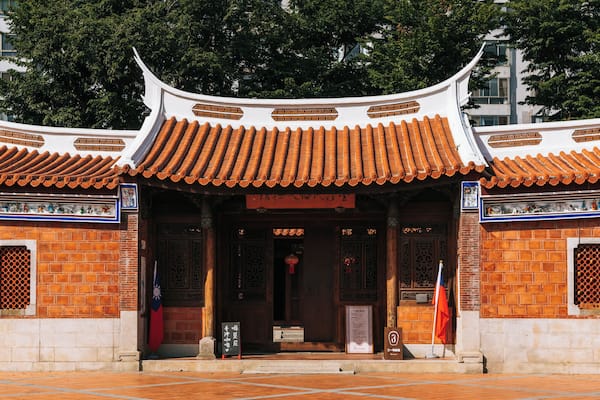 A traditional Chinese building with ornate red-tiled roofs and intricate wooden carvings.