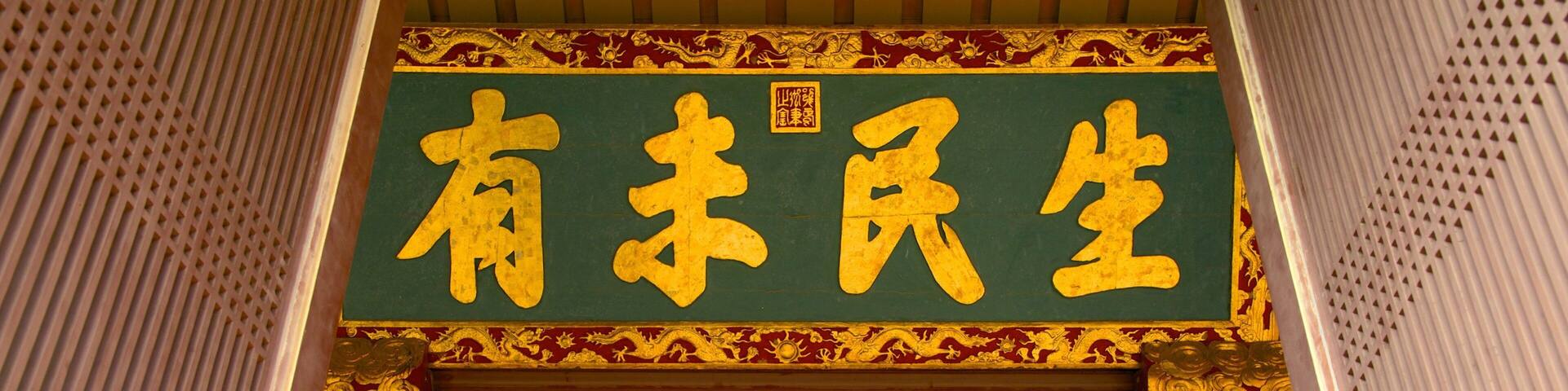A traditional Chinese architectural entrance with ornate decorations and golden Chinese characters.