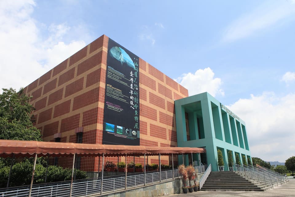 A large building with a prominent sign and a staircase leading to an entrance.