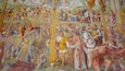 A detailed mural depicting a historical battle scene with soldiers, horses, and a central figure on a cross.