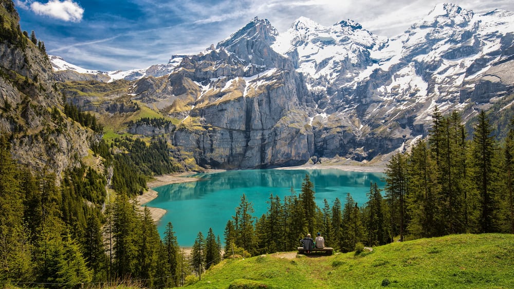 Amazing tourquise Oeschinnensee with waterfalls, wooden chalet and Swiss Alps, Berner Oberland, Switzerland.