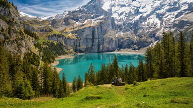 Amazing tourquise Oeschinnensee with waterfalls, wooden chalet and Swiss Alps, Berner Oberland, Switzerland.