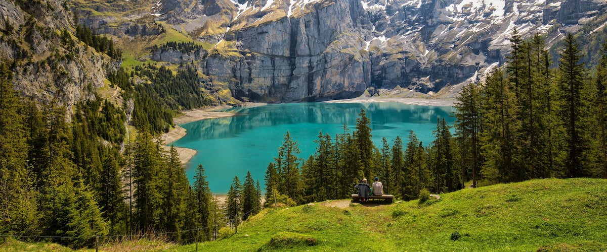 A mountain lake surrounded by rugged peaks and dense forests.