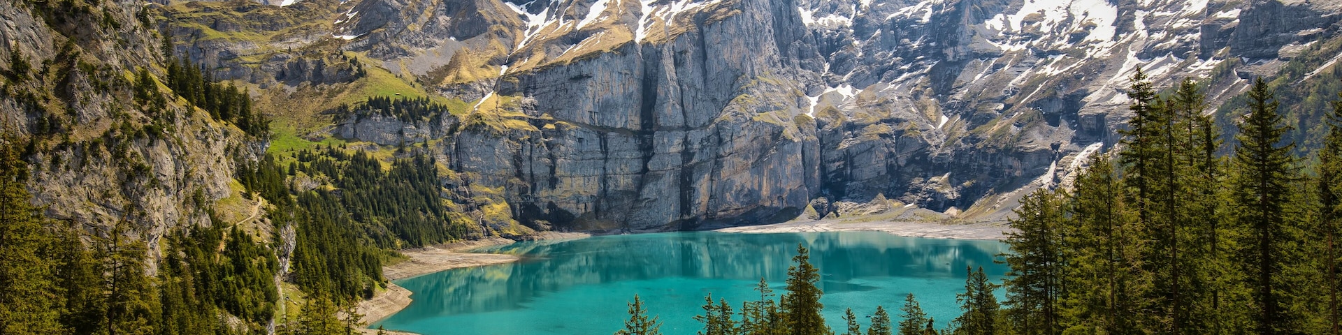 A mountain lake surrounded by rugged peaks and dense forests.