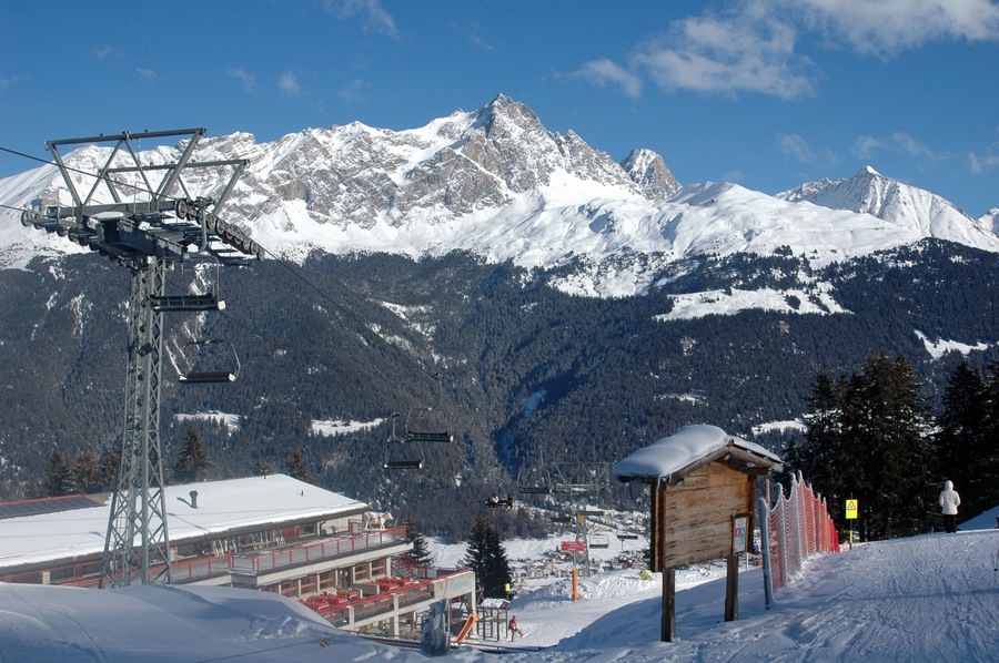 chair lift in a swiss ski resort called savognin with the alps on the horizon