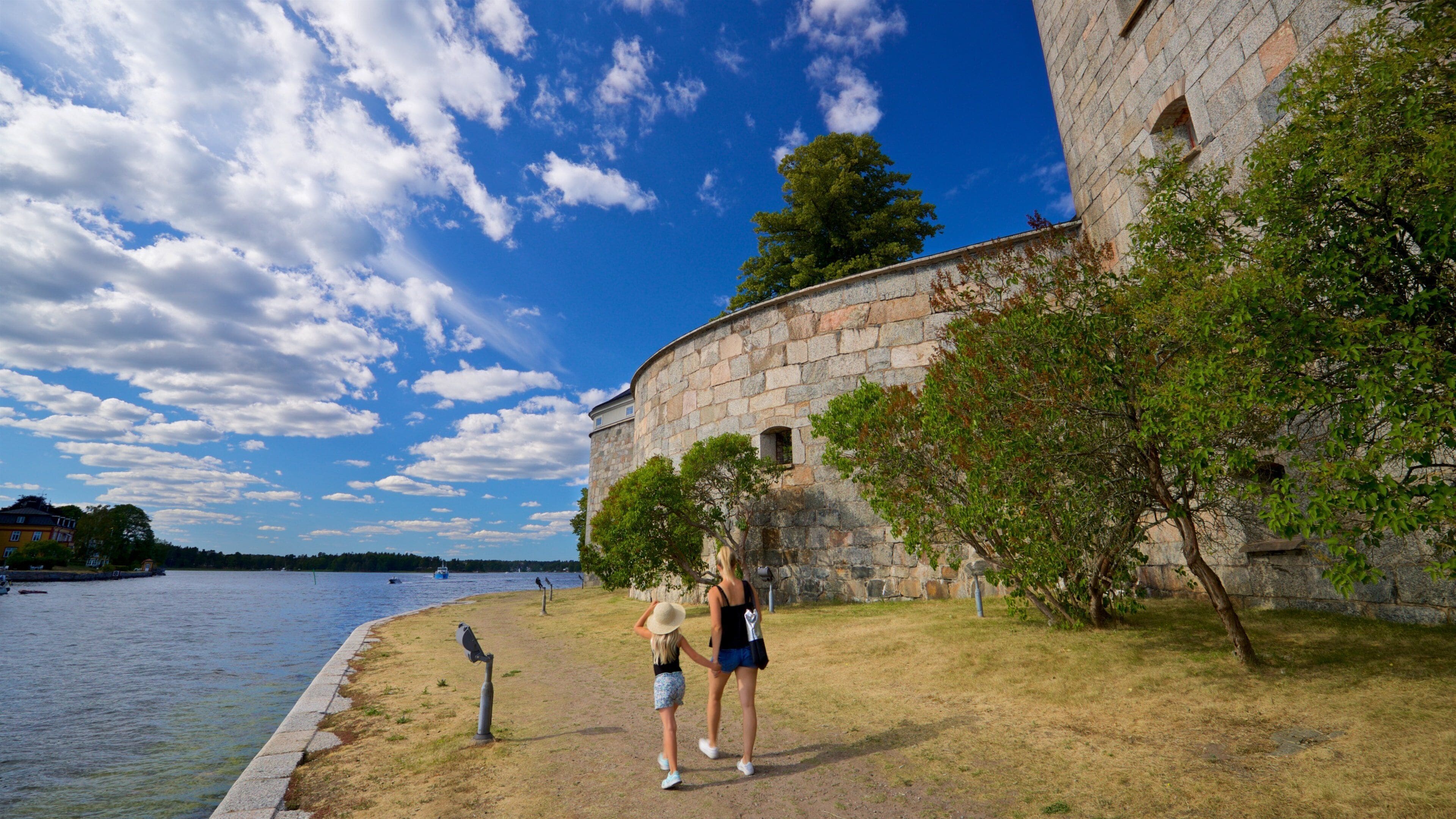 Vaxholm Fortress showing a river or creek and heritage elements as well as a family