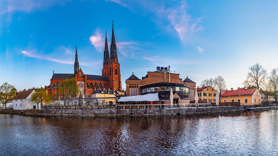 Sunset view of Uppsala cathedral reflecting on river Fyris in Sweden