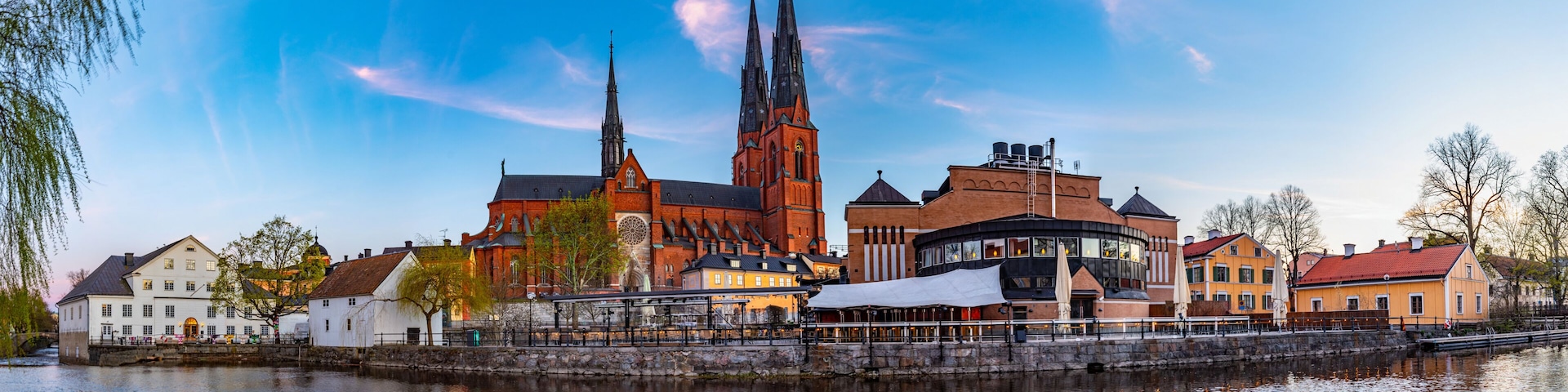 Sunset view of Uppsala cathedral reflecting on river Fyris in Sweden
