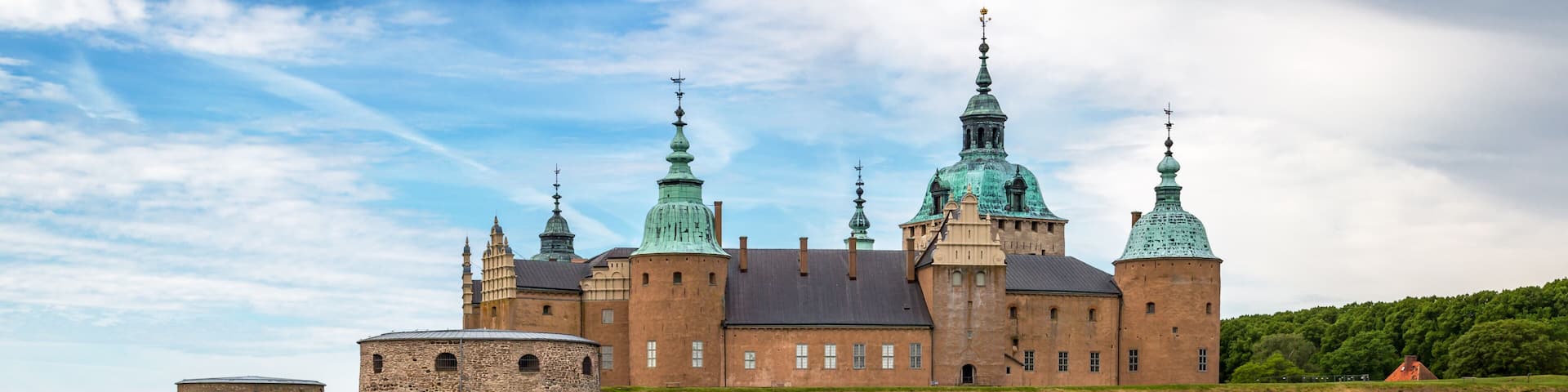 Kalmar Castle on a quiet summer morning with reflection in the calm water in the foreground.