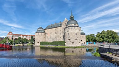 Orebro castle reflecting in water on sunny summer day in city Orebro, Sweden