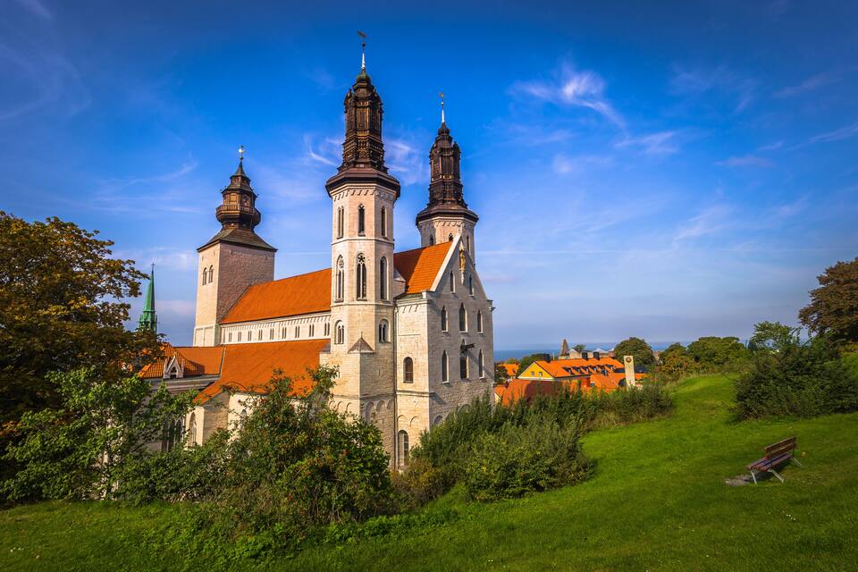 A historic church with two prominent towers and a red-roofed building.