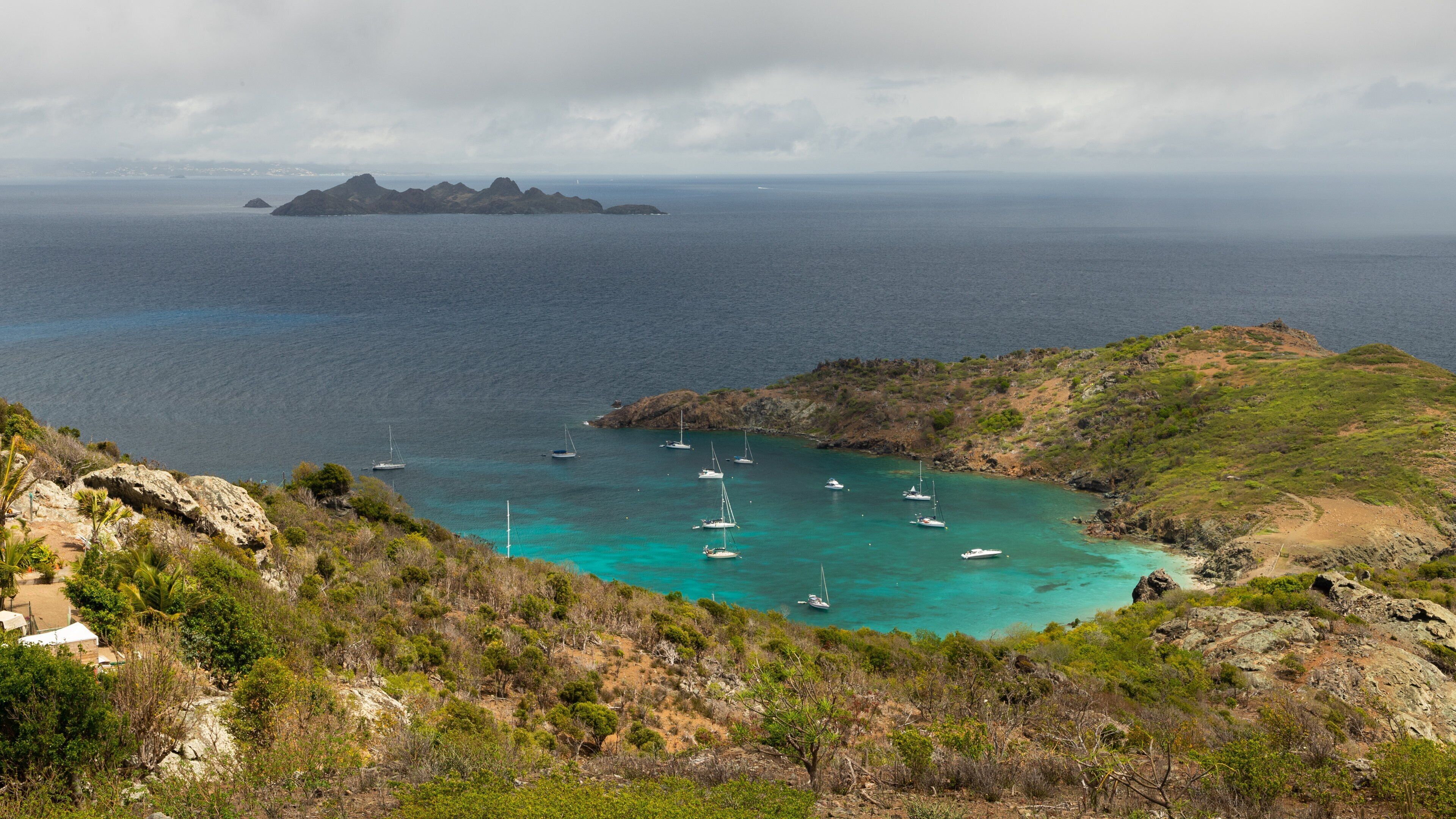 Colombier Beach which includes landscape views, rugged coastline and island views