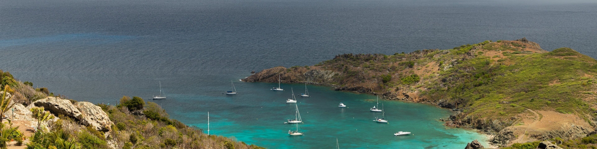 Colombier Beach which includes landscape views, rugged coastline and island views