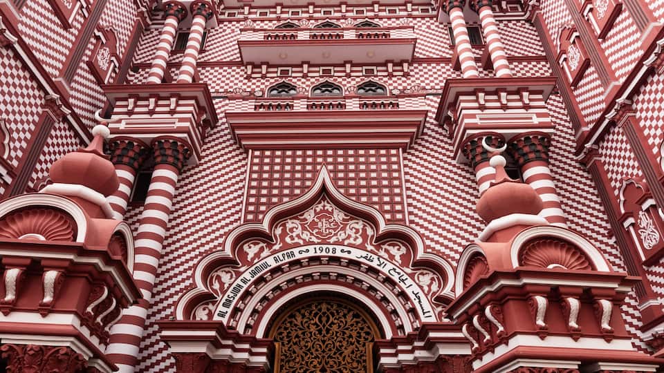 A detailed architectural facade with intricate patterns and a central arched entrance.