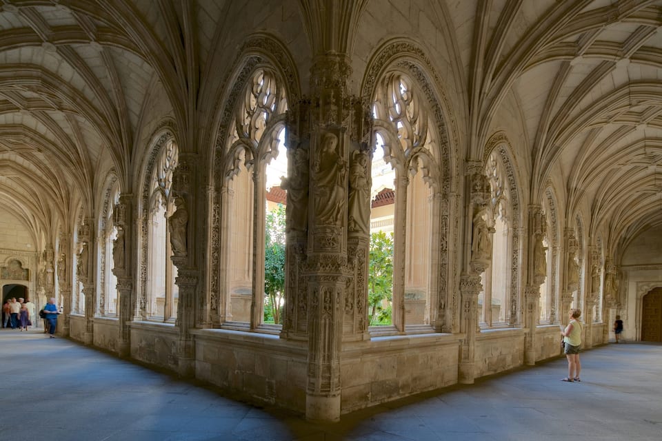A cathedral interior with Gothic arches and statues.